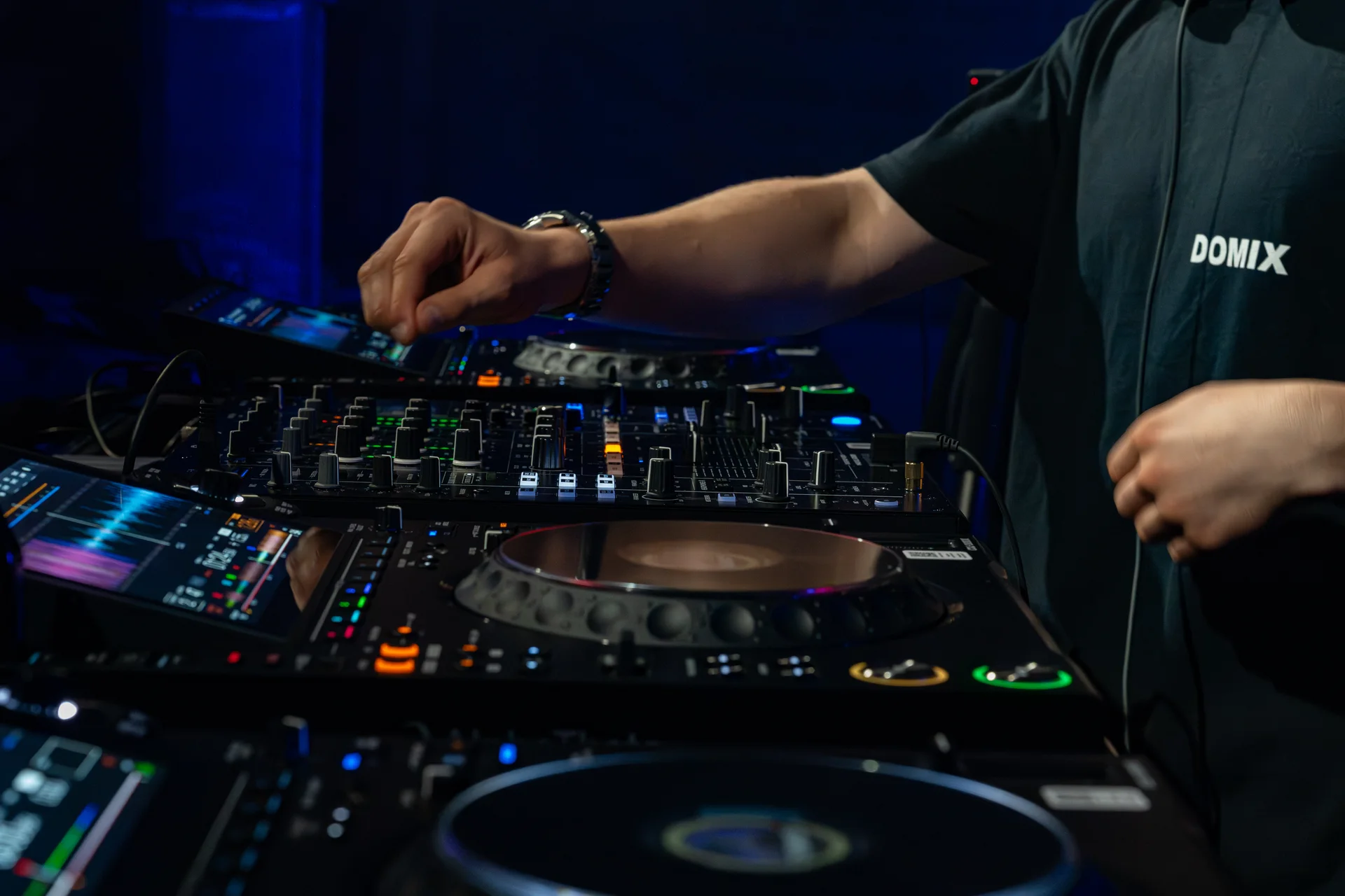 DOMIX adjusting DJ equipment during a performance